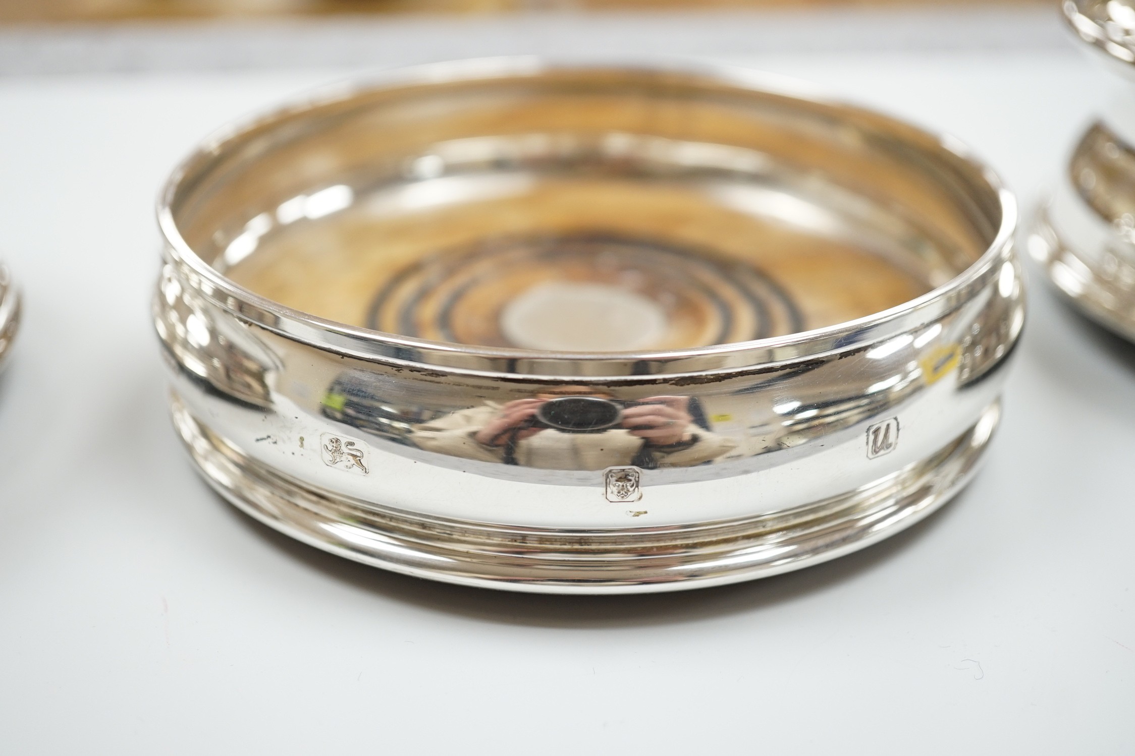 A pair of modern silver wine coasters, diameter 12.4cm and a single silver mounted wine coaster.